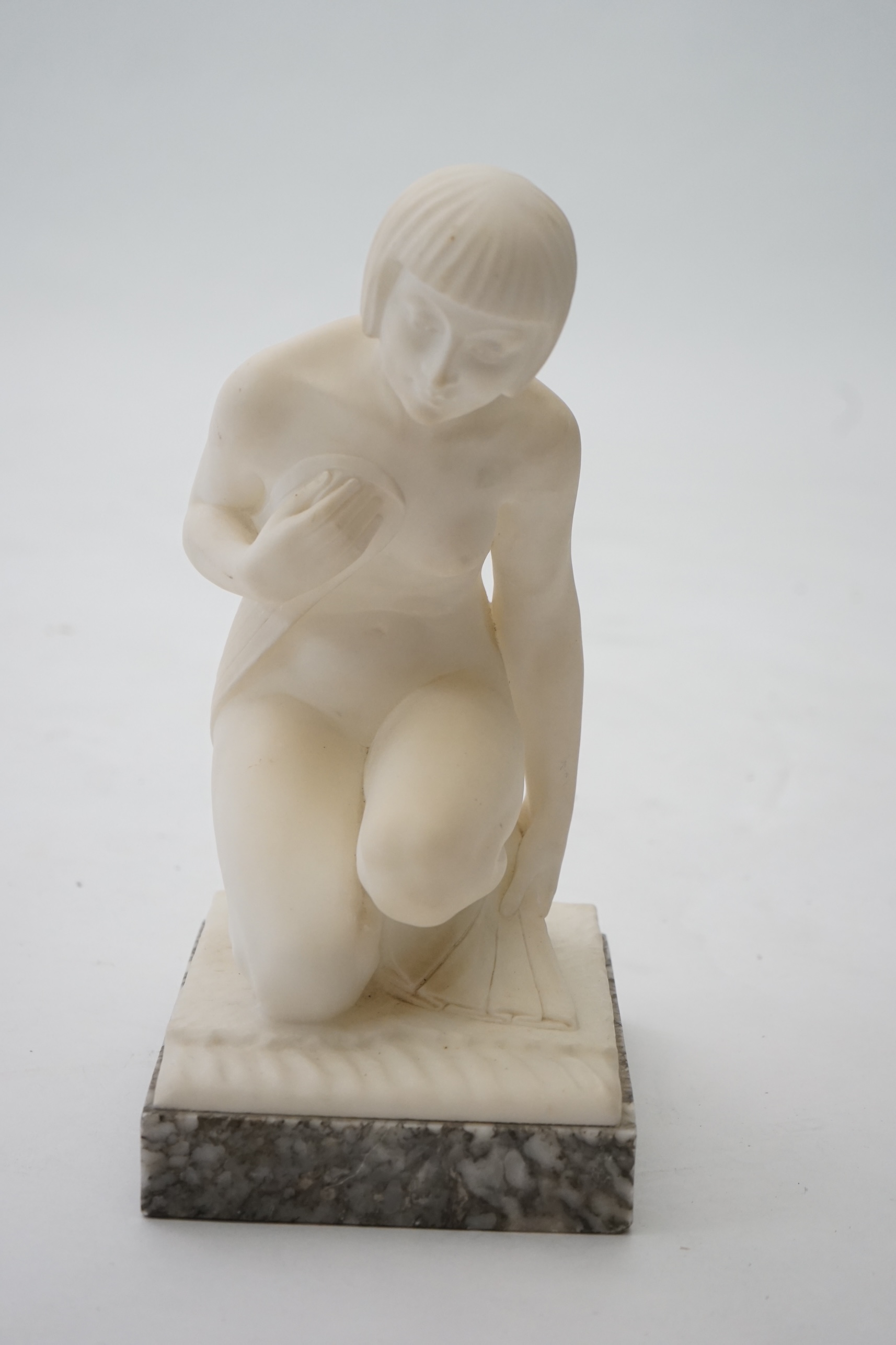 Manner of Gugliemo Pugi (1850-1915). An Italian Art Deco carved marble figure of a crouching bather kneeling and semi-draped